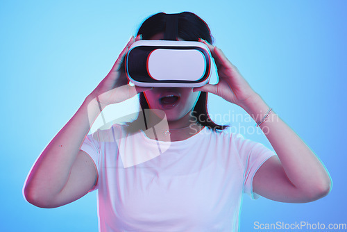 Image of Woman, VR technology and surprise in studio for user experience, digital world and future multimedia game on blue background. Virtual reality glasses, metaverse and wow for innovation of UX gaming