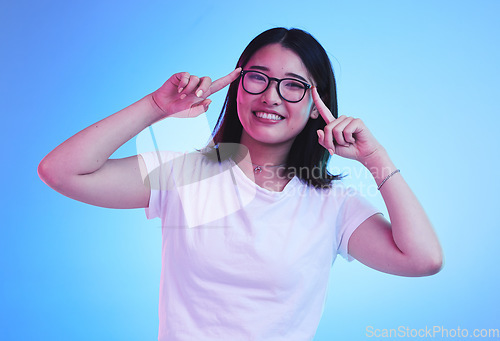 Image of Portrait, thinking and Asian woman with glasses, ideas and opportunity on a blue studio background. Japanese person, face and model with eyewear, solution and decision with problem solving and choice