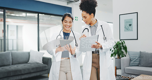 Image of Talking doctors, walking or tablet in busy hospital, teamwork or collaboration for surgery planning, medicine or life insurance app. Smile, happy or planning healthcare women on technology research