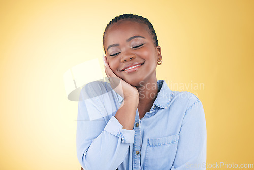 Image of Smile, black woman and skincare, touch and beauty in studio isolated on a yellow background mockup space. Happy, natural and African model in cosmetic facial treatment, health aesthetic and wellness