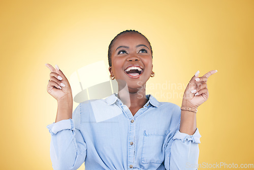 Image of Pointing up, choice or excited black woman in studio for mockup space, sale news or deal offer. Yellow background, advertising or happy person thinking of promotion ideas, announcement or retail deal