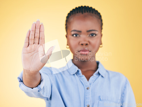 Image of Black woman, hand and stop, warning and caution in portrait with communication isolated on yellow background. Gesture, emoji and censored, palm and no entry with protest, fight and conflict in studio