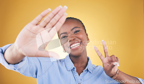 Image of Selfie, peace sign and smile with portrait of black woman in studio for motivation, social media and influencer. Happy, freedom and profile picture with face of person on yellow background for post