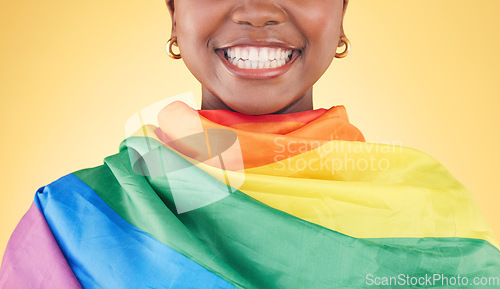 Image of Woman, mouth closeup and rainbow flag in studio for smile, teeth or happy for inclusion by yellow background. Lesbian girl, cloth or fabric for lgbtq equality, gay pride or excited for sign or vote