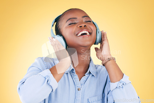 Image of Black woman, happiness and headphones with music, energy and audio streaming isolated on yellow background. Sound, entertainment and radio with freedom, person with fun and technology in a studio