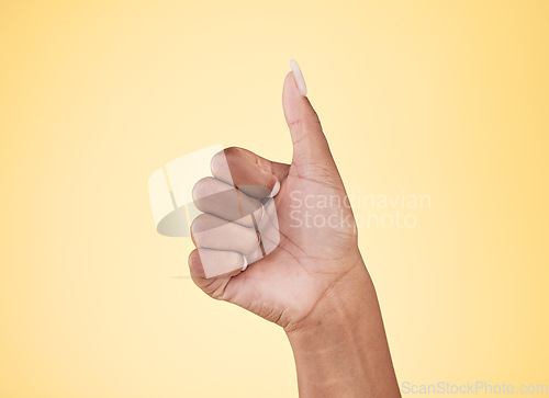 Image of Woman, hands and thumbs up in winning, success or approval against a studio background. Closeup of female person with like emoji, yes sign or okay in thank you, agreement or finger gesture on mockup