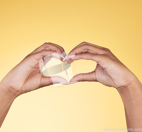 Image of Woman, heart hands and symbol for love, support or care in trust against a studio background. Closeup of female person with loving emoji, gesture or sign in romance, valentines day or shape on mockup