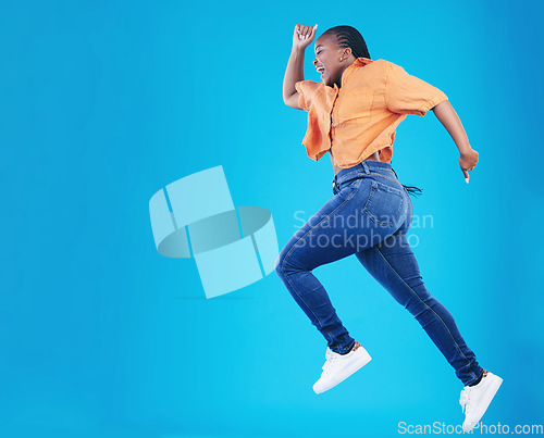 Image of Jump, black woman and excited with motivation in studio from celebration and smile. Happy, energy and African female person with mockup space and blue background with leap from deal and announcement