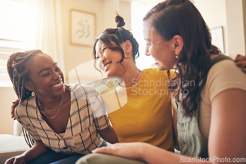 Image of Happy, hug and women friends gossip, speaking and bond with care, trust and story in their home. Smile, embrace and people with diversity in a living room with support, conversation and social visit