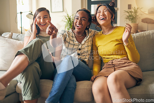 Image of Happy, friends and women watching tv on a sofa laughing, bond and relax in their home on the weekend. Television, movie and people with diversity in living room for streaming, film or comedy in house