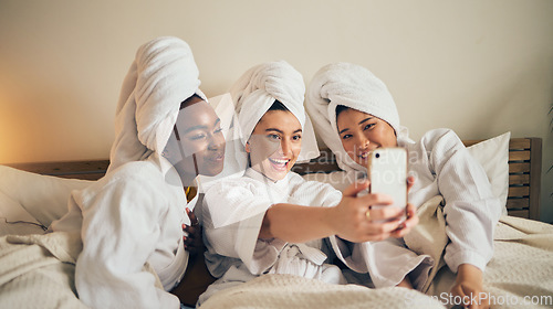 Image of Spa day, selfie and friends in bed relax with social media during skincare routine at home. Bedroom, self care and women beauty influencer with smartphone smile for profile picture, blog or podcast