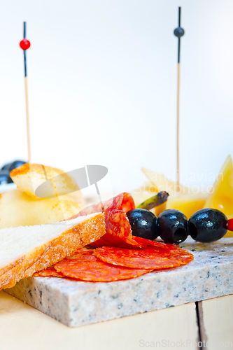 Image of mix cold cut on a stone with fresh pears