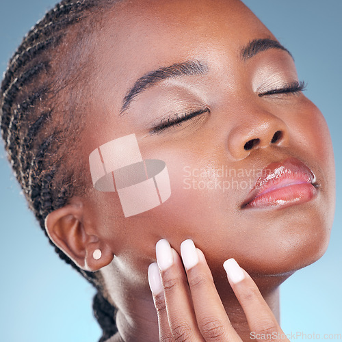Image of Beauty, skin and a black woman with hand on face for dermatology, natural makeup and manicure. Closeup of African person on a studio background with cosmetics and facial glow, shine or soft touch