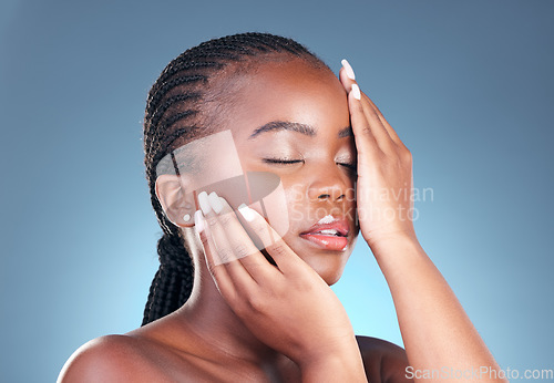 Image of Beauty, black woman and relax with skincare, cosmetics and facial wellness in a studio. Blue background, makeup and dermatology with skin glow and shine from treatment with manicure and calm detox