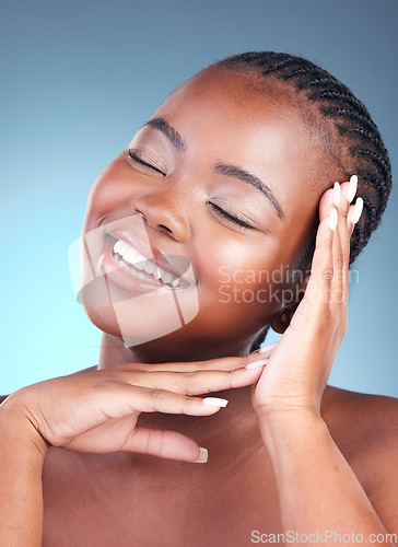 Image of Beauty, black woman and smile with skincare, cosmetics and facial wellness in a studio. Blue background, makeup and dermatology with skin glow and shine from treatment with manicure and calm detox