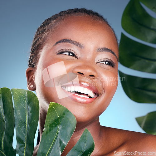 Image of Beauty face, leaf and black woman happiness for natural self care, cosmetics or sustainable product. Studio, plant and clean African person with monstera, eco friendly and skincare on blue background