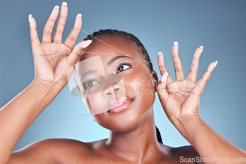 Image of Eyebrow pluck, thread and beauty of a woman with dermatology, natural makeup and skincare. Face of an African person on a studio background with cosmetics, hair removal and facial glow or self care