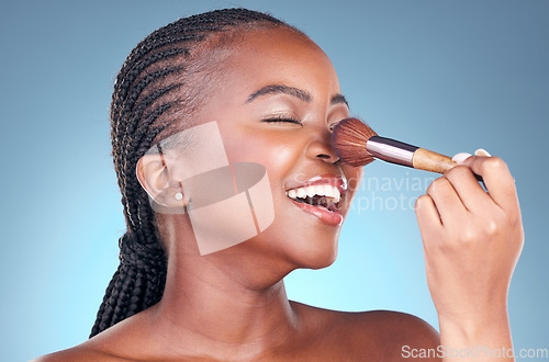 Image of Studio, face and black woman with brush for makeup application, facial skincare or beauty routine. Cosmetics, spa dermatology and African person with cosmetology tools on blue gradient background