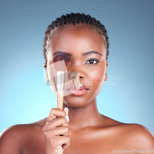 Image of Studio portrait, black woman and brush for makeup powder application, facial foundation or beauty routine. Cosmetics product, cosmetology tools and African female model on blue gradient background