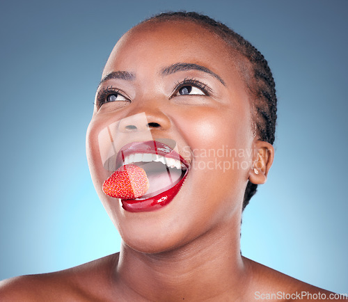 Image of Skincare, strawberry and black woman with beauty, health and wellness on a blue studio background. Person, fruit and model with cosmetics, diet and nutrition with grooming, aesthetic and dermatology