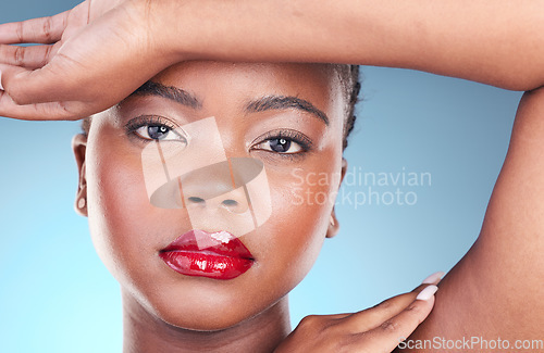 Image of Portrait, beauty and black woman with makeup, dermatology or cosmetics on a blue studio background. Face, person or model with lip gloss, red lipstick or wellness with health, shine and aesthetic