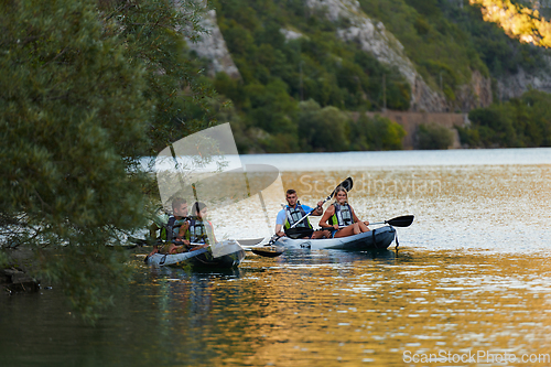 Image of A group of friends enjoying having fun and kayaking while exploring the calm river, surrounding forest and large natural river canyons