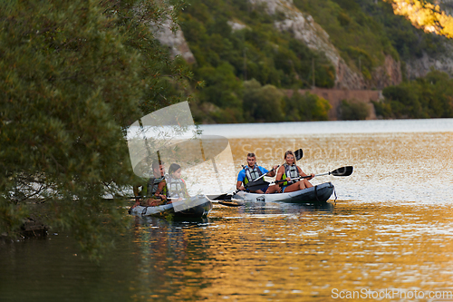 Image of A group of friends enjoying having fun and kayaking while exploring the calm river, surrounding forest and large natural river canyons