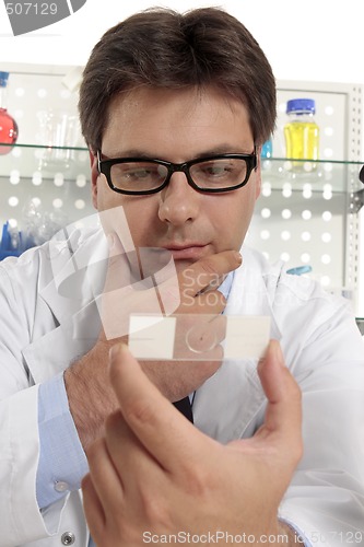 Image of Scientist studies a microscope slide