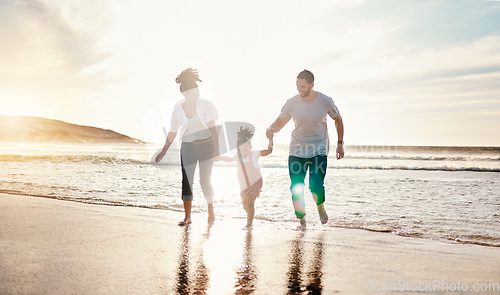 Image of Playing, beach and family walking together on a vacation, adventure or holiday together for bonding. Sunset, having fun and girl child with her mother and father on the sand by ocean on weekend trip.
