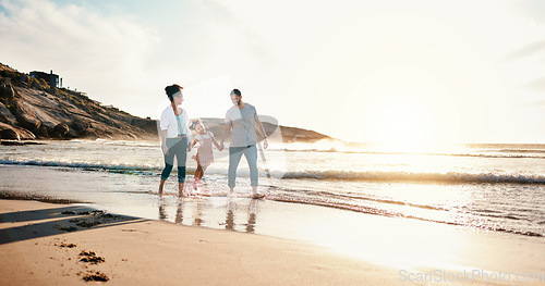 Image of Walking, bonding and family on the beach for vacation, adventure or holiday together at sunset. Travel, having fun and girl child with her mother and father on the sand by the ocean on weekend trip.