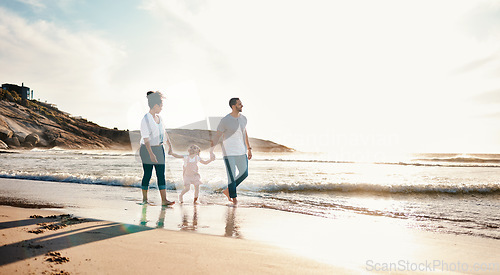 Image of Walking, holding hands and family on the beach at sunset on vacation, adventure or holiday together. Travel, bonding and girl child with her mother and father on the sand by the ocean on weekend trip