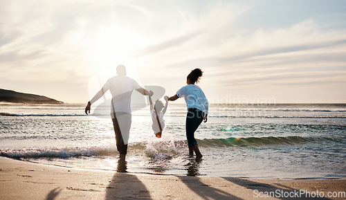 Image of Mom, dad and swing girl on beach, holiday and vacation in Florida for bonding, adventure and family together in waves. Mother, father and child at sunset in ocean, sea or playing in water for fun