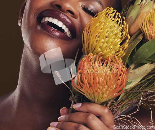 Image of Smile, beauty and protea with the face of a black woman in studio on brown background for natural treatment. Skincare, plant or cosmetics and a young model aesthetic wellness with eco flowers