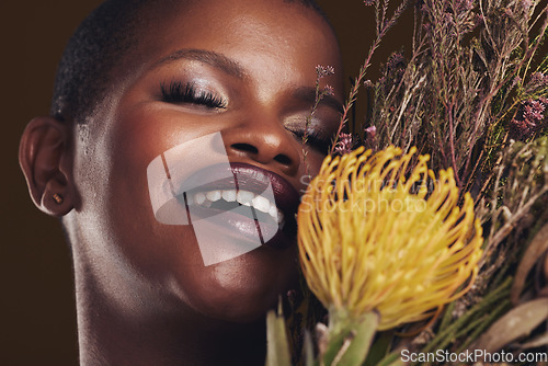 Image of Skincare, beauty and protea with the face of a black woman in studio on brown background for natural treatment. Smile, plant or cosmetics and a young model for sustainability or wellness with flowers