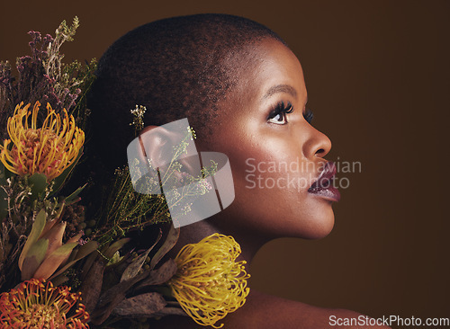 Image of African woman, flowers and studio profile for beauty, wellness or thinking with vision by brown background. Girl, model and facial makeup for skin, sustainable cosmetics or idea for healthy aesthetic