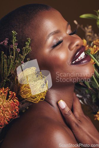 Image of Skincare, beauty and protea flower with a black woman in studio on brown background for natural treatment. Face, plant or cosmetics and a young model indoor for aesthetic wellness with a smile