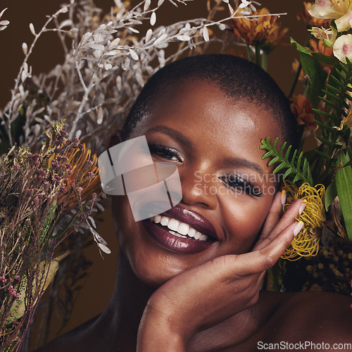 Image of African woman, plants and makeup in studio portrait with beauty, wellness and natural glow by brown background. Girl, model and face with leaves, flowers and happy for cosmetics, shine or aesthetic