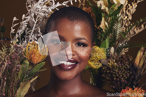 Image of African woman, flowers and makeup in studio portrait with beauty, wellness or natural glow by brown background. Girl, model and face with leaves, plants and happy for cosmetics, skincare or aesthetic