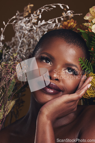 Image of African woman, plants and thinking in studio with flowers for beauty, wellness or natural glow by brown background. Girl, model and face with leaves, ideas and memory for cosmetics, skin or aesthetic