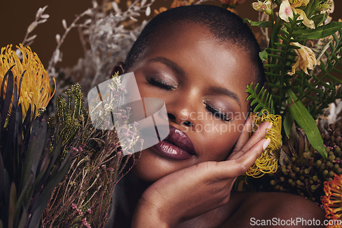 Image of Beauty, makeup and plants with face of black woman in studio for natural, spa and environmental. Cosmetics, flowers and dermatology with model on brown background for sustainability and glow