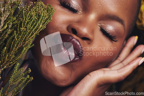 Image of African woman, plants and makeup in studio with kiss, beauty and wellness with lipstick, skin and closeup. Girl, model and face with leaves, pouting or happy for cosmetics, shine or aesthetic in zoom