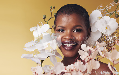 Image of Black woman, flowers and beauty with portrait, smile with makeup and natural cosmetics isolated on studio background. African model, orchid and nature, sustainable skincare and with facial and glow