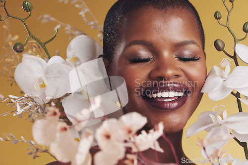 Image of Black woman, flowers and beauty with smile, makeup and natural cosmetics isolated on studio background. African model, orchid and nature, sustainable skincare with eyes closed, facial and glow