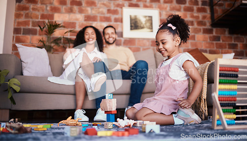 Image of Happy, playing and a child with building blocks and parents for relax, education and learning in a house. Smile, playful and a girl kid with toys and a mother and father in a living room as family