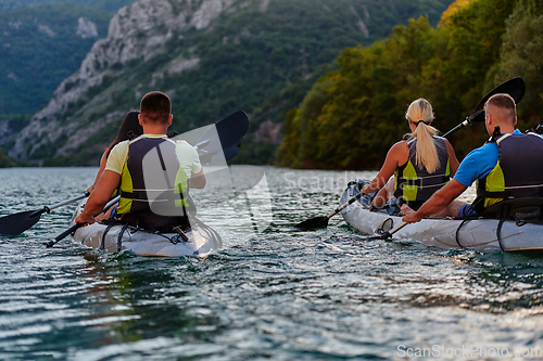 Image of A group of friends enjoying having fun and kayaking while exploring the calm river, surrounding forest and large natural river canyons