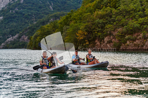 Image of A group of friends enjoying having fun and kayaking while exploring the calm river, surrounding forest and large natural river canyons