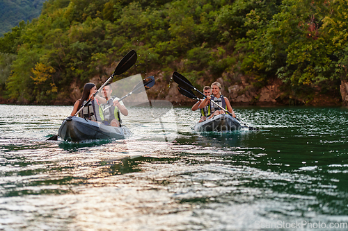 Image of A group of friends enjoying having fun and kayaking while exploring the calm river, surrounding forest and large natural river canyons