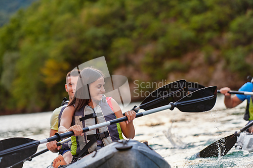 Image of A young couple enjoying an idyllic kayak ride in the middle of a beautiful river surrounded by forest greenery