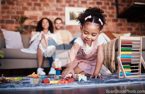 Image of Child, toys and playing in home with development and building block in living room. Family, fun and youth learning with a young girl and parents in a house together with care and bonding education
