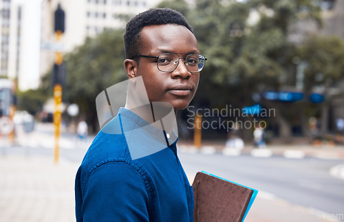 Image of Portrait, serious student and black man in city outdoor to travel to university school. Face, glasses and African learner or college person in Kenya in urban street with book in education or studying